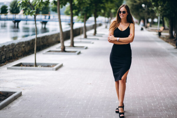Femeie în rochie neagră pe promenada râului